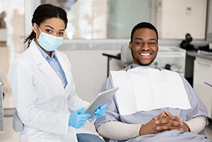 Patient and dentist smiling while reviewing information on tablet