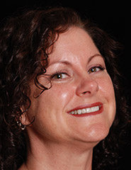 Brunette woman smiling with whiter and more evenly aligned teeth