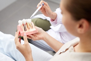 dentist showing a patient a model of dental implants in Virginia Beach