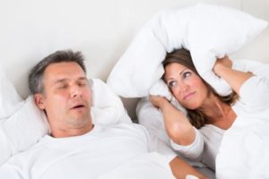 Woman annoyed by man's snoring