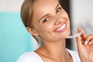 Woman holding Invisalign clear braces