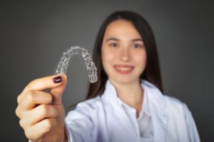 person holding Invisalign aligners