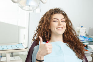 woman thumb up in dental chair