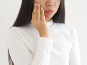 woman with jaw pain in need of neuromuscular dentistry