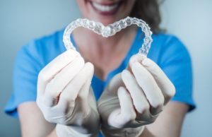 dentist holding invisalign trays