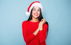 Woman with good oral health wearing a Santa hat