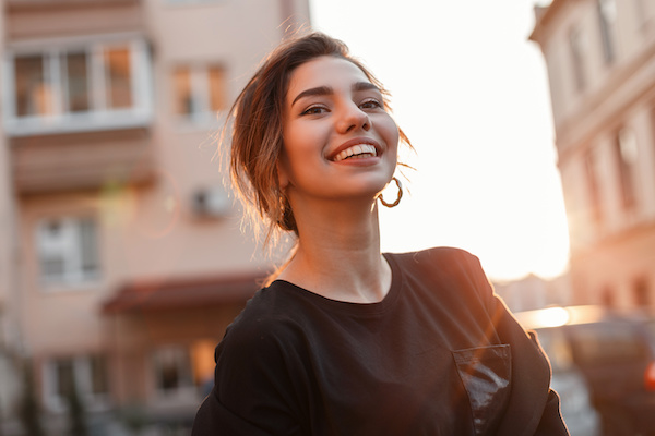 young woman smiling, cityscape
